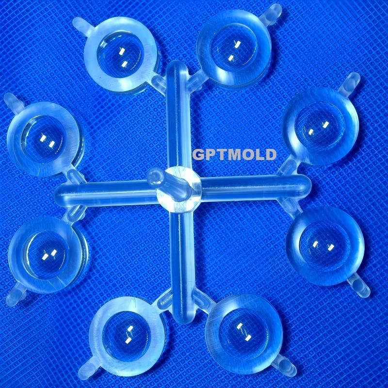 Six clear circular molded components connected by a central runner on a blue background