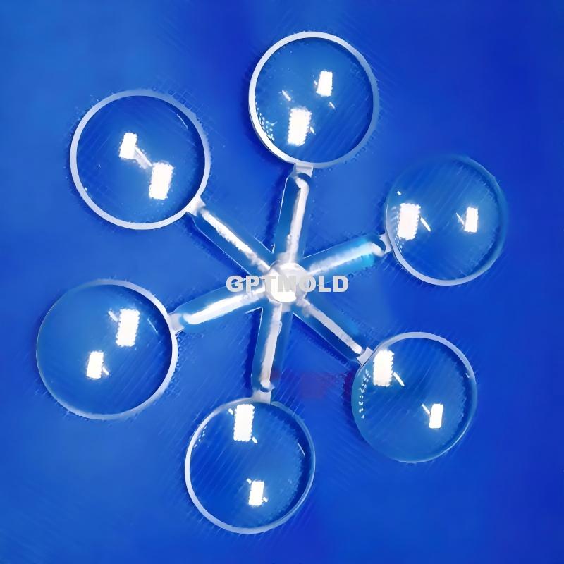 Clear round molded components arranged around a central runner on a blue background